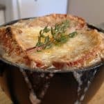 French Onion Soup in mug with melted cheese and thyme