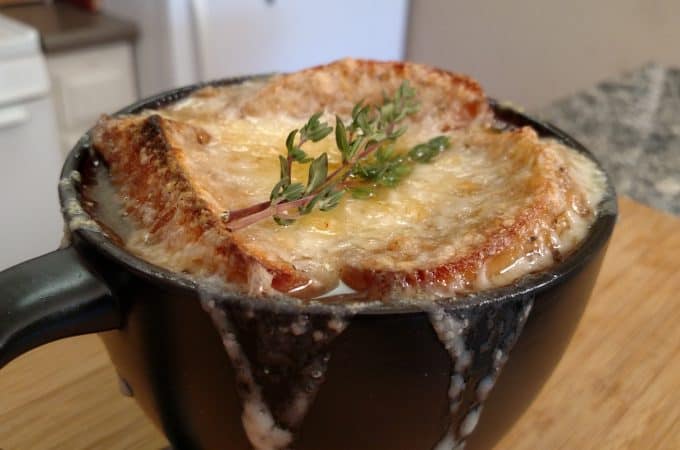 French Onion Soup in mug with melted cheese and thyme