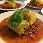 Spinach Lasagne Roll-ups with basil on an white plate