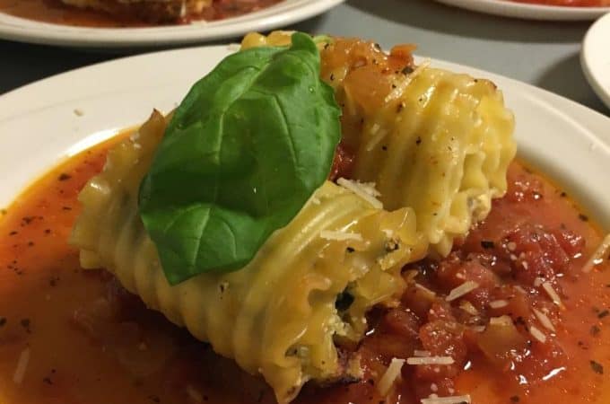 Spinach Lasagne Roll-ups with basil on an white plate