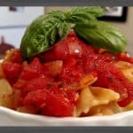 Tomato Sauce on farfalle pasta in white dish with basil
