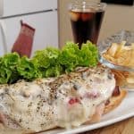 sandwich on a plate with soda and chips