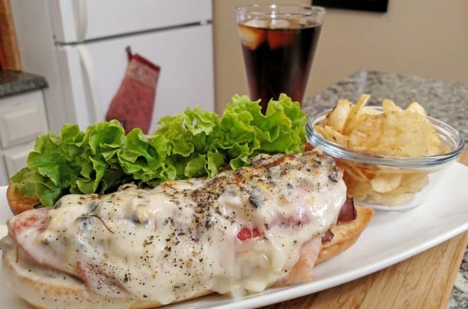 sandwich on a plate with soda and chips
