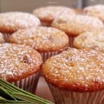 Close up of Orange Cranberry Muffins with powered sugar, rosemary