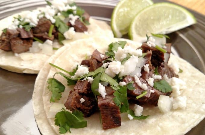 Street Tacos on corn tortilla with chopped onion, cilantro and lime wedges