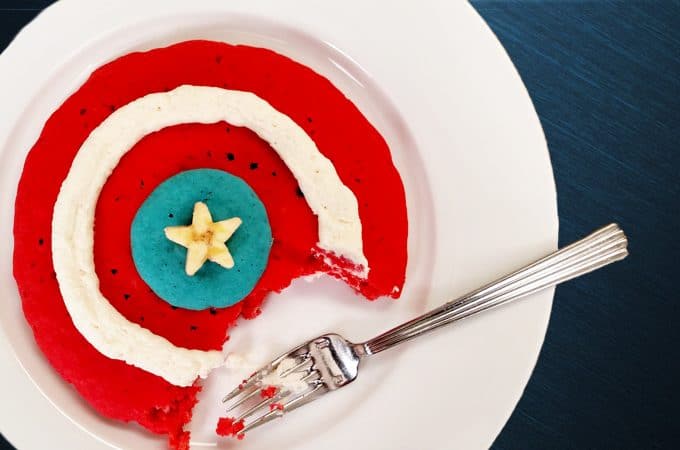 Captain America Shield Pancakes, red white blue pancakes with folk and banana star on white plate