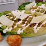 Grilled Caesar Salad and crouton and cheese on White plate in kitchen