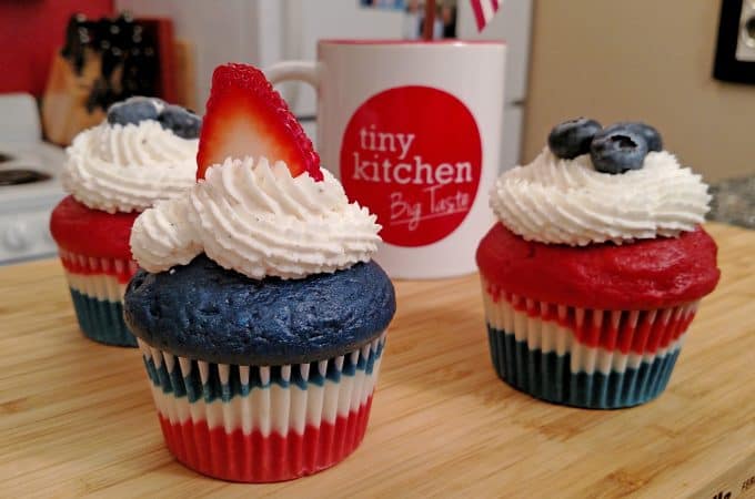 Red, White and Blue Velvet Cupcakes with Buttercream frosting, blueberries and strawberries with a Tiny Kitchen Big Taste coffee mug