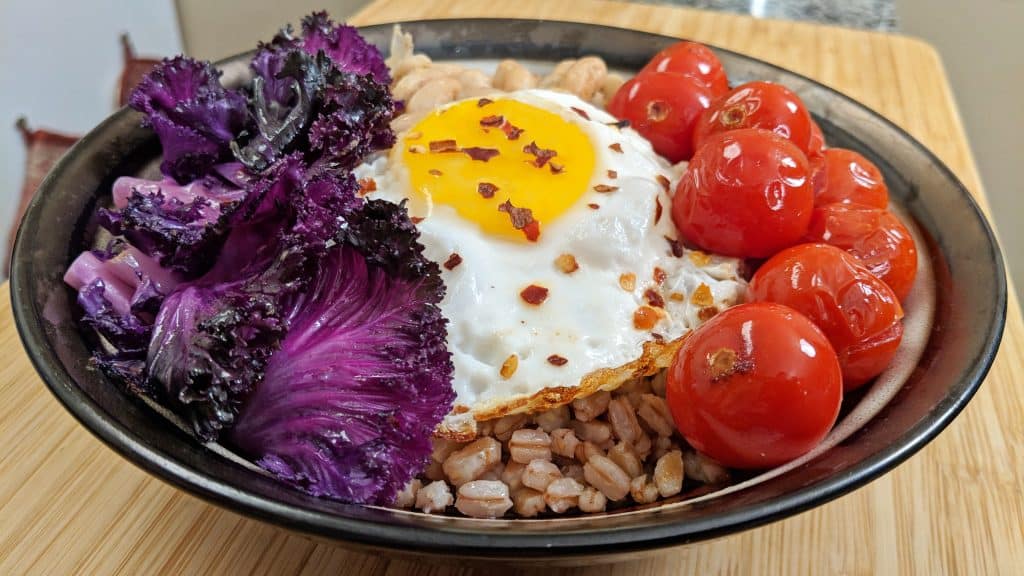 Farro Grain Bowl with Purple Kale, Cherry Tomatoes, Cannellini Bean and a Fried Egg