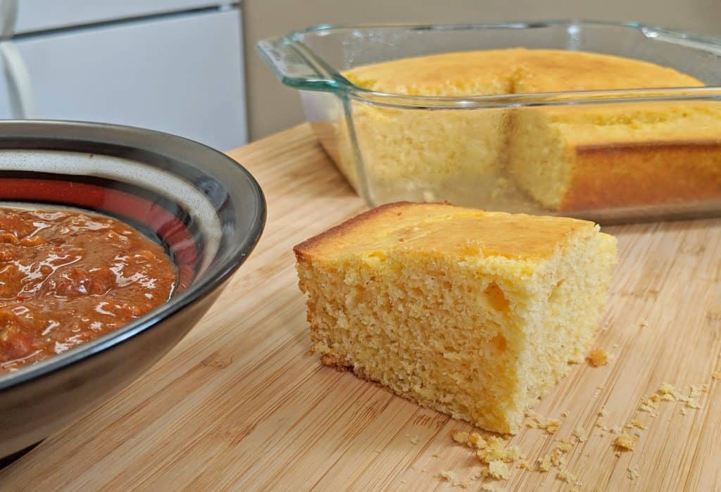 Piece of Cornbread with Pan of Cornbread with Bowl of Chili