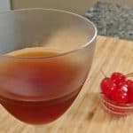 Manhattan in Nick and Nora glass with maraschino cherries on board
