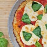 Keto Pizza with a Gluten Free Cauliflower Crust with fresh basil on brown cutting board. margherita pizza, Neapolitan pizza