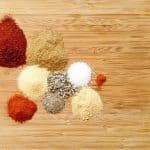 piles of spices on bamboo cutting board